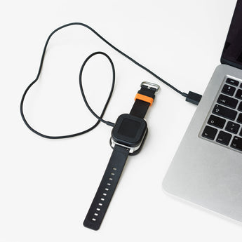 Sort Xplora X6 oplader med magnetisk stik og USB-kabel. Designet til nem opladning af X6 Play og X6 Pro.