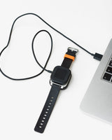 Sort Xplora X6 oplader med magnetisk stik og USB-kabel. Designet til nem opladning af X6 Play og X6 Pro.