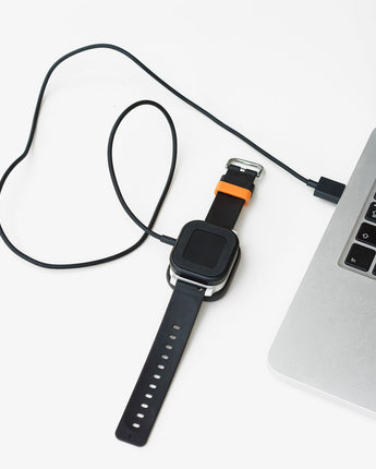 Sort Xplora X6 oplader med magnetisk stik og USB-kabel. Designet til nem opladning af X6 Play og X6 Pro.