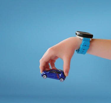 Barn med et smartwatch til børn fra Xplora leger med en lille blå bil