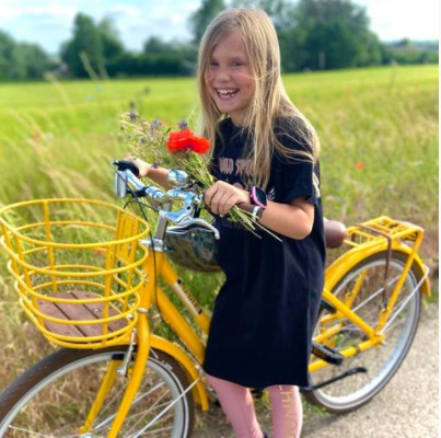 Pige med sin cykel og Xplora smartwatch på håndleddet